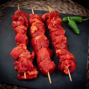 3 pinchos morunos sobre una tabla de cocina